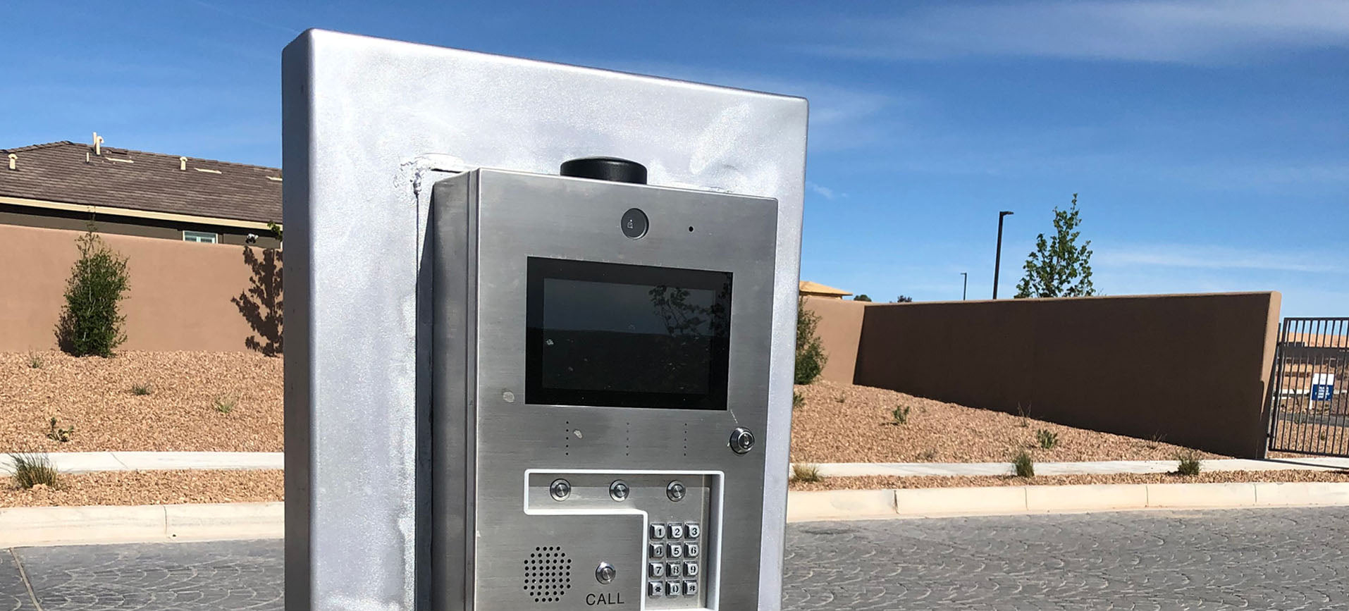 custom design stainless steel stand holds keypad and intercom gate opener at entrance to neighborhood